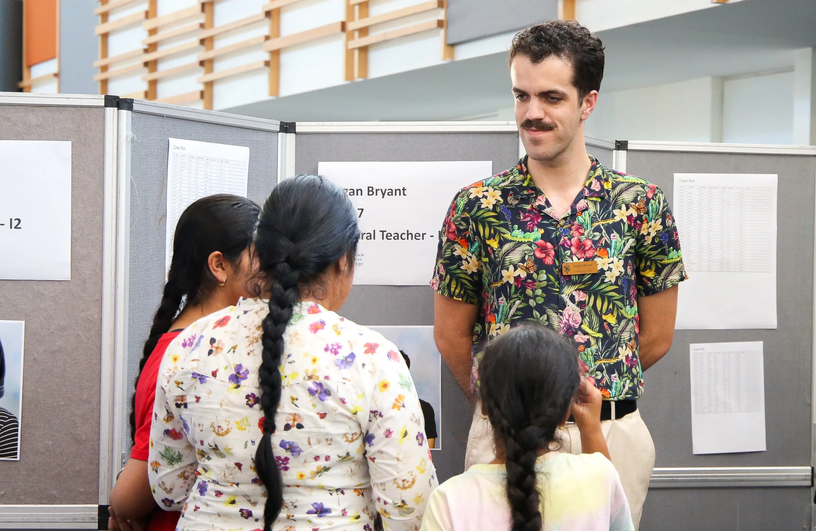 A male teacher talking to a family